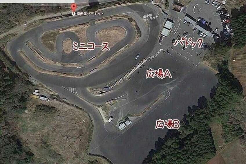 A racetrack with multiple turns and a pit area. 2