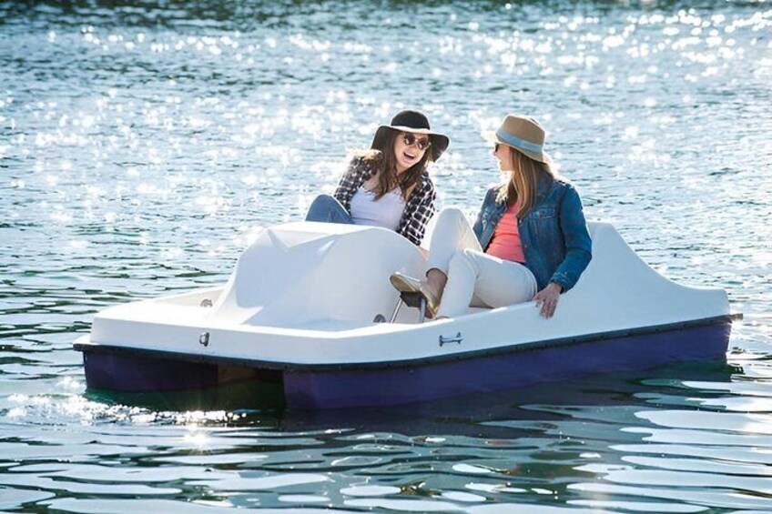 Two people on a small motorboat on calm water. 1