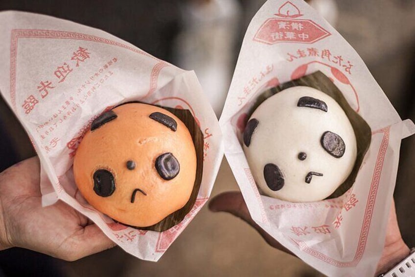 Two pastries with faces, one orange and one white, held in hands. 3