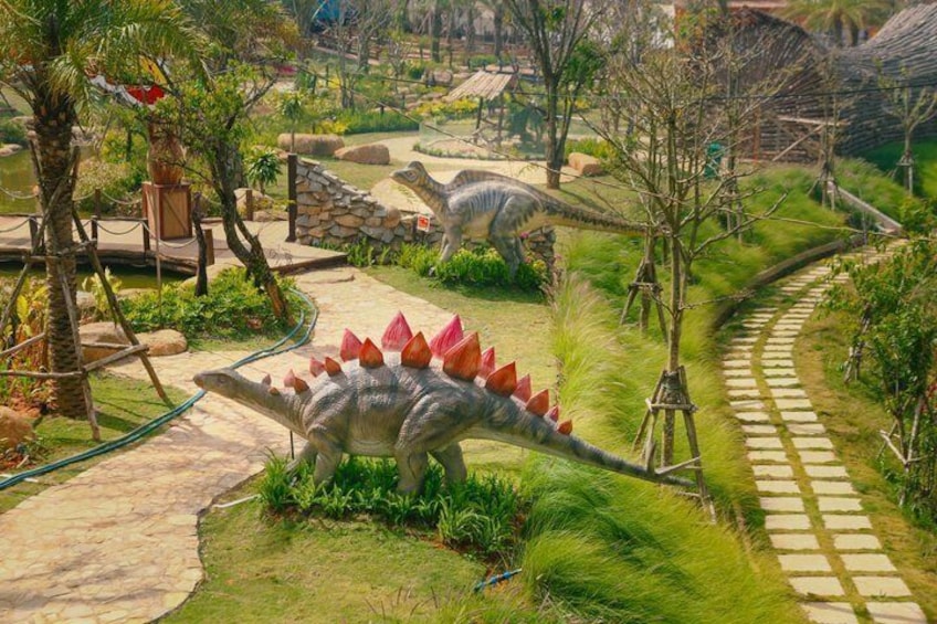 A dinosaur exhibit with a pathway and a large dinosaur model. 3