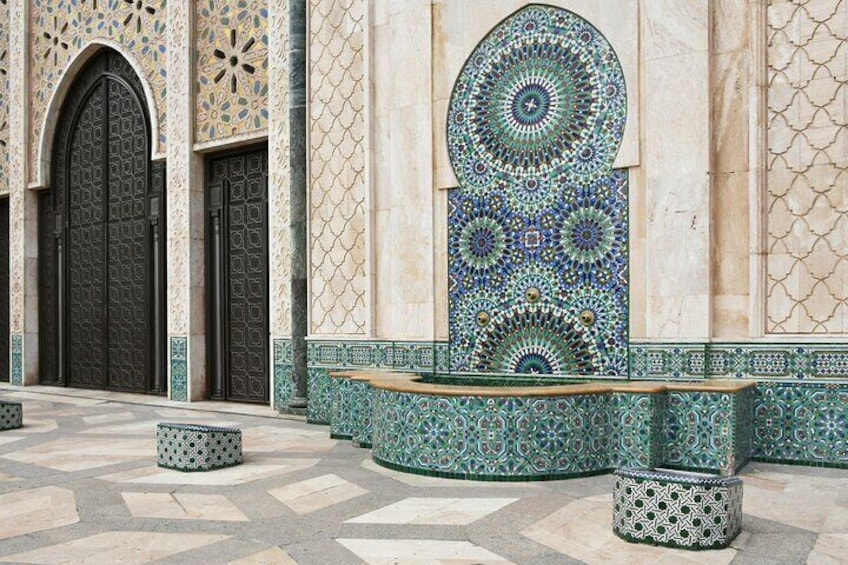 A building with ornate tile work, large arched doors, and a patterned wall. 5