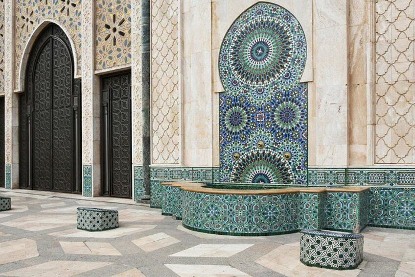 A building with intricate tile work, large arched doors, and a patterned wall. 5
