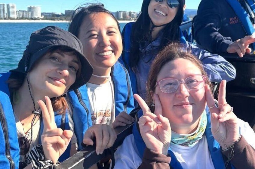 A group of people on a boat with a city skyline in the background. 4