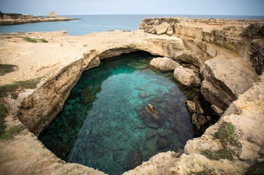 A natural rock formation with a clear water pool. 4