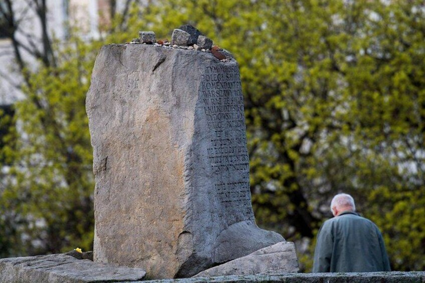 A tall stone monument with inscriptions, surrounded by trees. 2