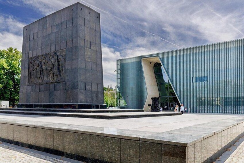A modern building with a unique curved entrance and a large square structure with a relief sculpture. 4