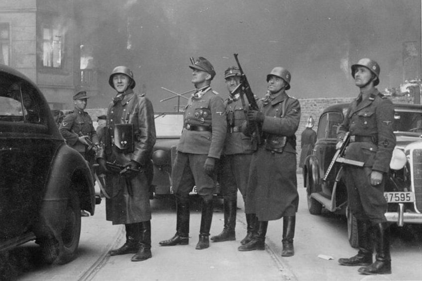 Soldiers in military uniforms standing in a line with rifles, in front of vintage cars. 5