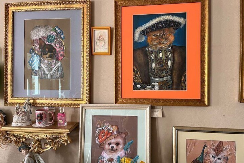 A wall with various framed artworks, including portraits and decorative pieces. 1