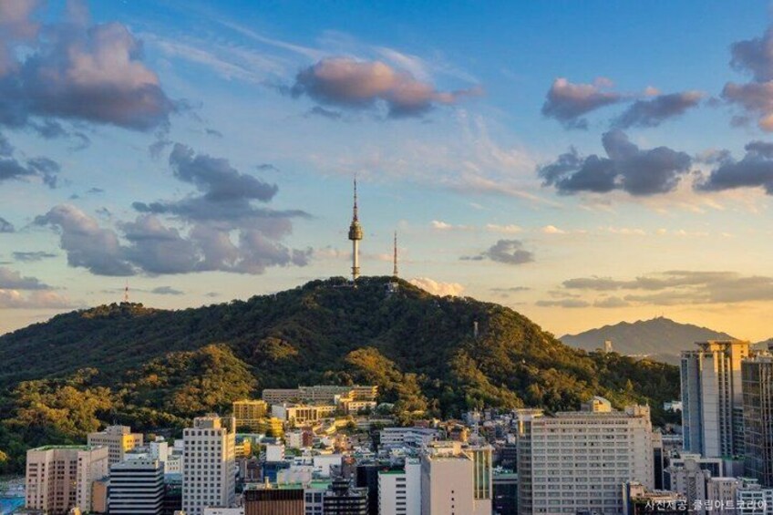 A cityscape with a prominent tower on a hill, surrounded by buildings and greenery. 5
