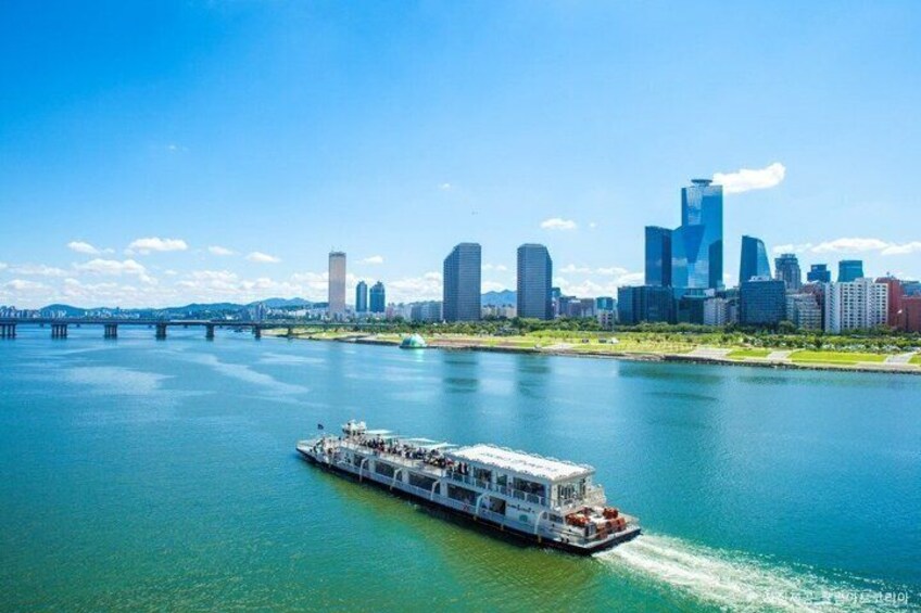 A riverboat on a river with a city skyline in the background. 2
