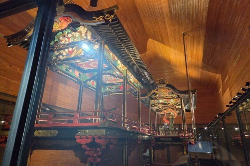 A carousel with ornate decorations and a wooden ceiling. 1