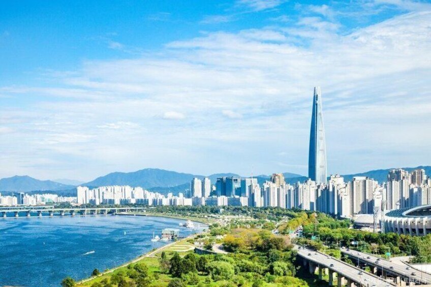 A city skyline with a prominent skyscraper, a river, and a bridge. 3