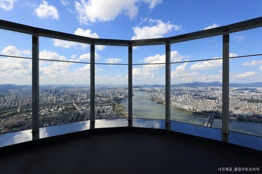 A panoramic view from a high-rise building with large windows overlooking a cityscape and a river. 2