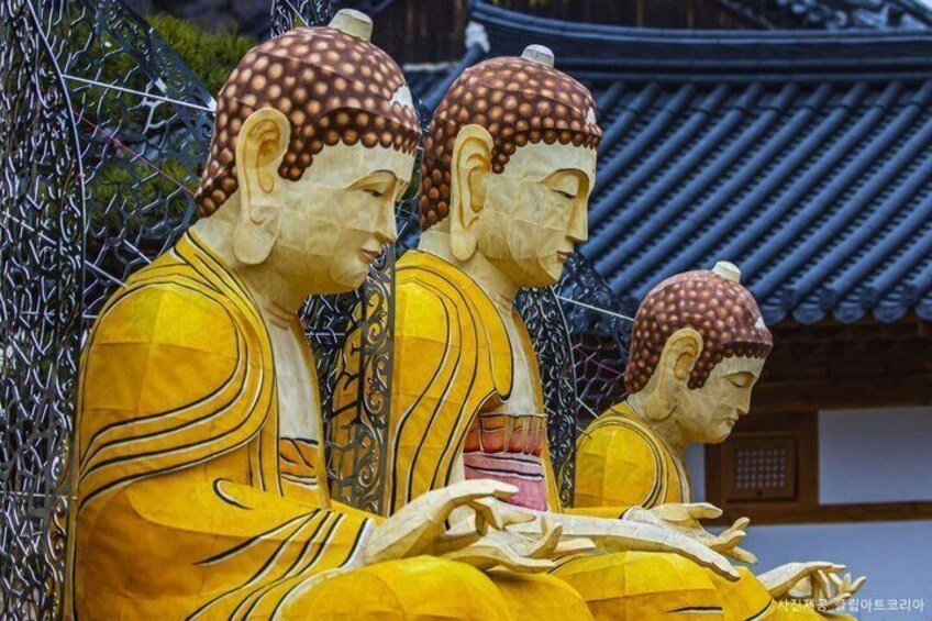 A Buddha statue in a traditional temple setting. 4