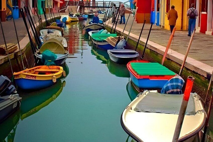 A narrow canal with small boats docked along the sides. 2