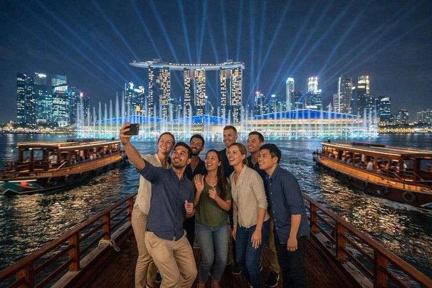 A group of people taking a selfie on a boat with a city skyline in the background. 5
