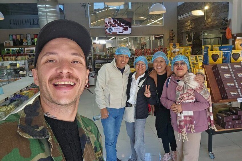 A group of people in a store with shelves of products and a sign that reads 'CHOCOLATE.' 4