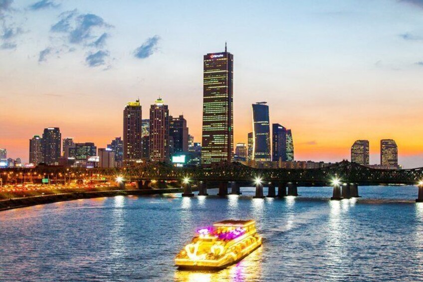 A city skyline at dusk with illuminated buildings and a bridge over a river. 4