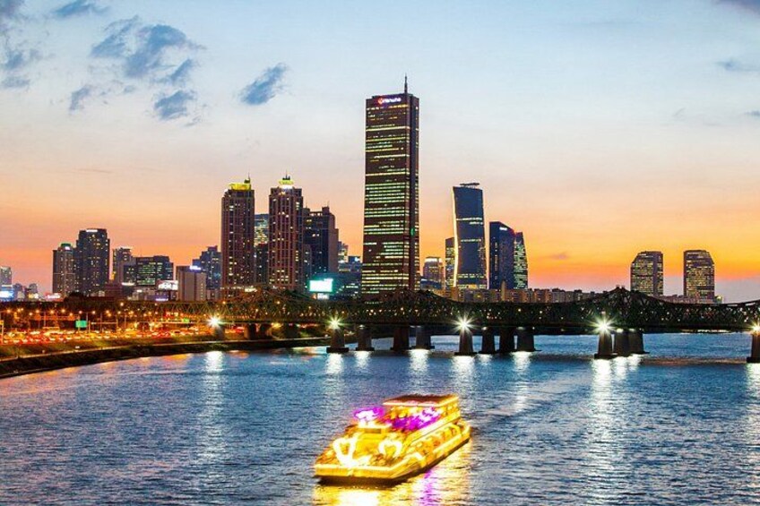 A city skyline at dusk with illuminated buildings and a bridge over a river. 4