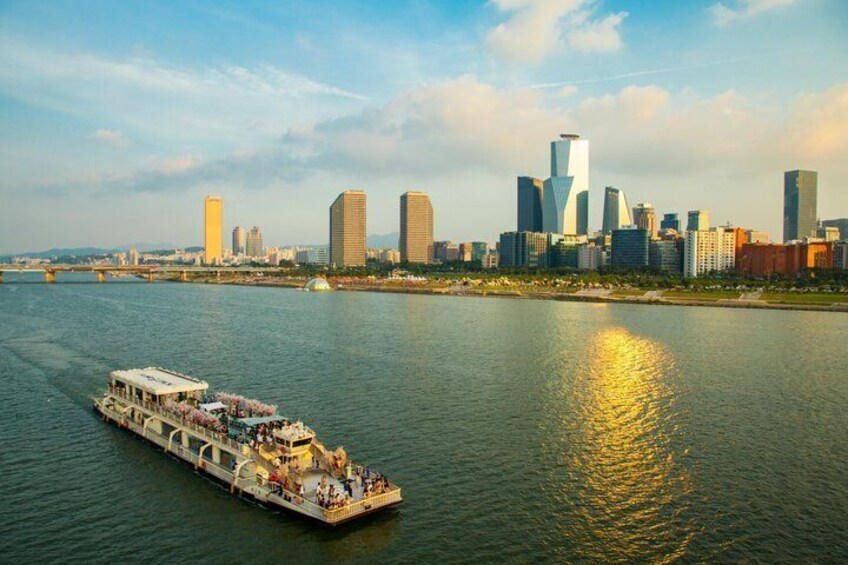 A riverboat with passengers, a city skyline, and a bridge in the background. 1
