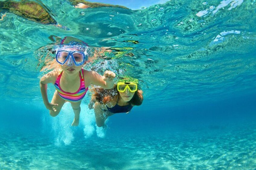 Two people snorkeling underwater in clear blue water. 4
