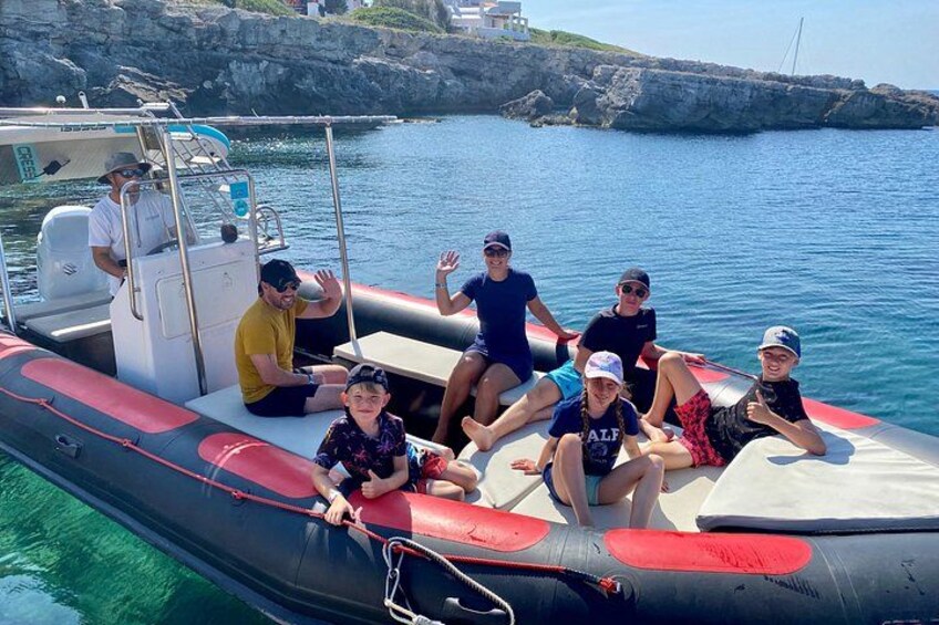 A group of people on a small inflatable boat near rocky coast. 1