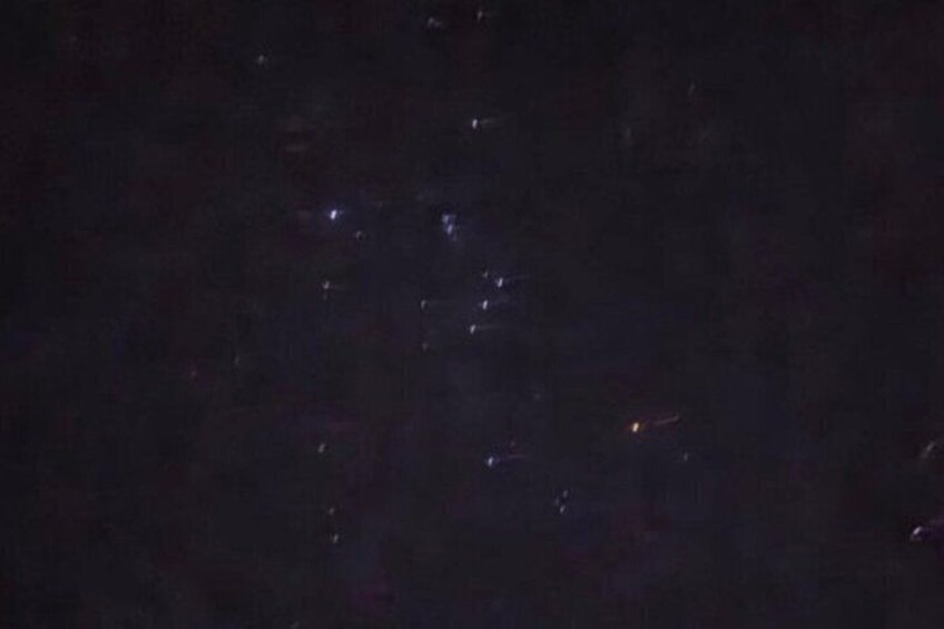 A dark night sky with faint, scattered lights. 5