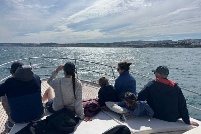 A group of people on a boat, looking out at the water. 1