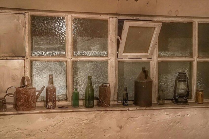 A window with various old bottles and a lantern. 5