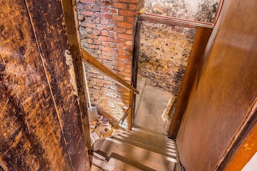 A wooden staircase with a brick wall in the background. 3