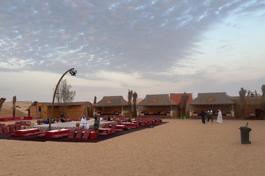 A desert resort with red seating, palm trees, and traditional buildings. 5
