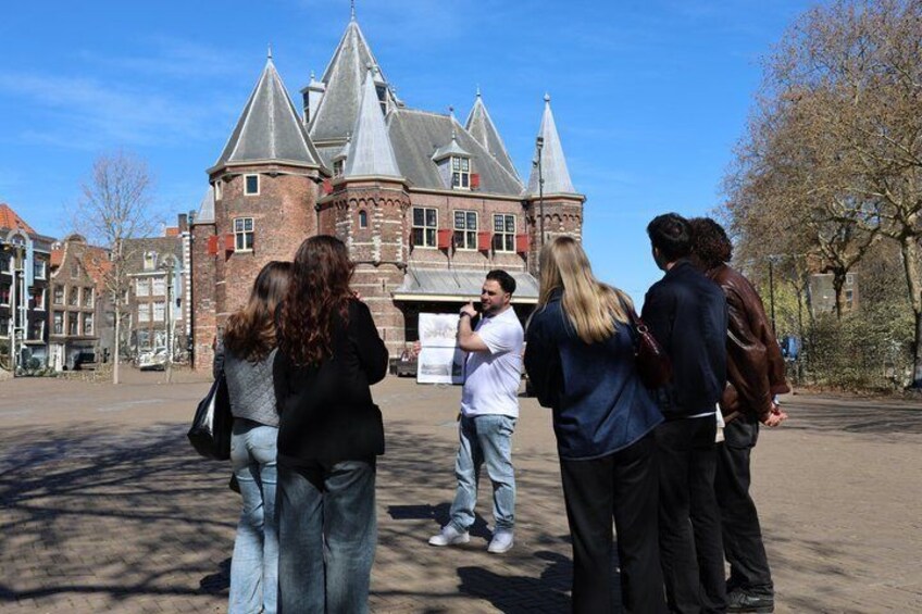 A group of people standing in front of a historic building with a tower. 5