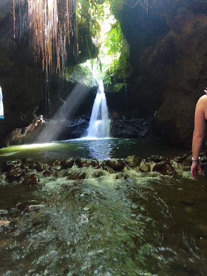 A waterfall in a cave with water flowing over rocks. 3