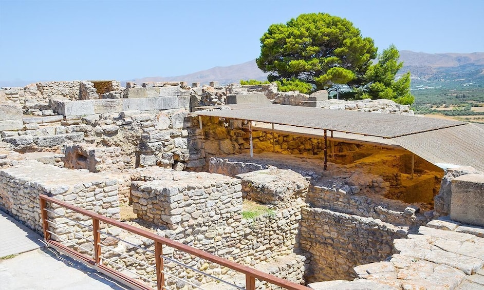 Ancient stone ruins with a metal railing in the foreground. 4