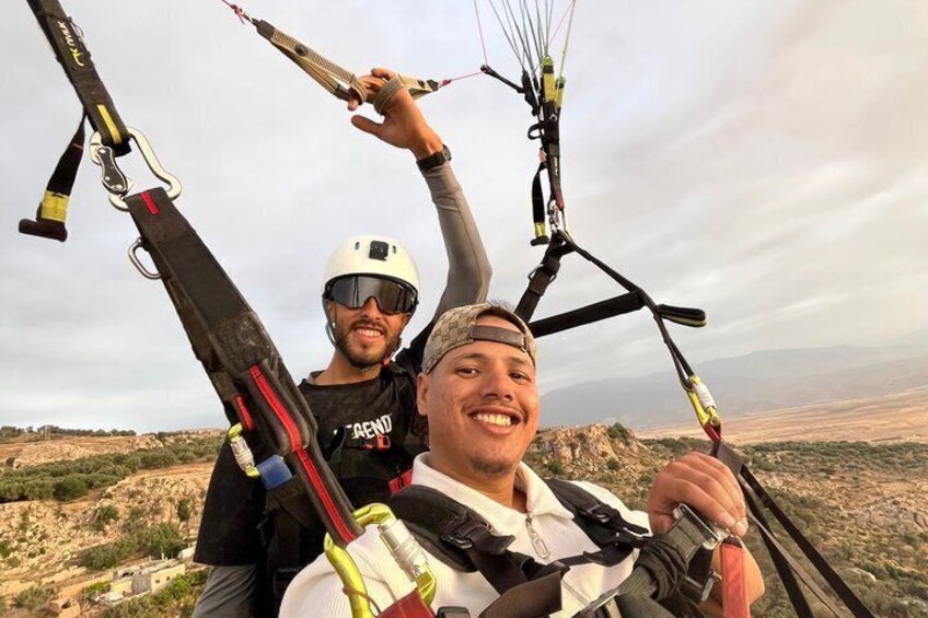Two people with kites, one holding a kite, in a desert landscape. 2