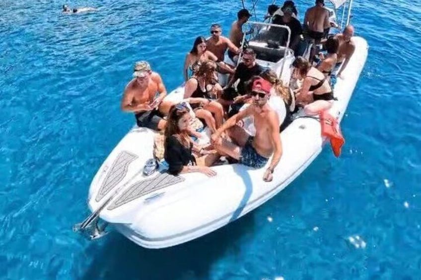 A group of people on a small white boat in a body of water. 1