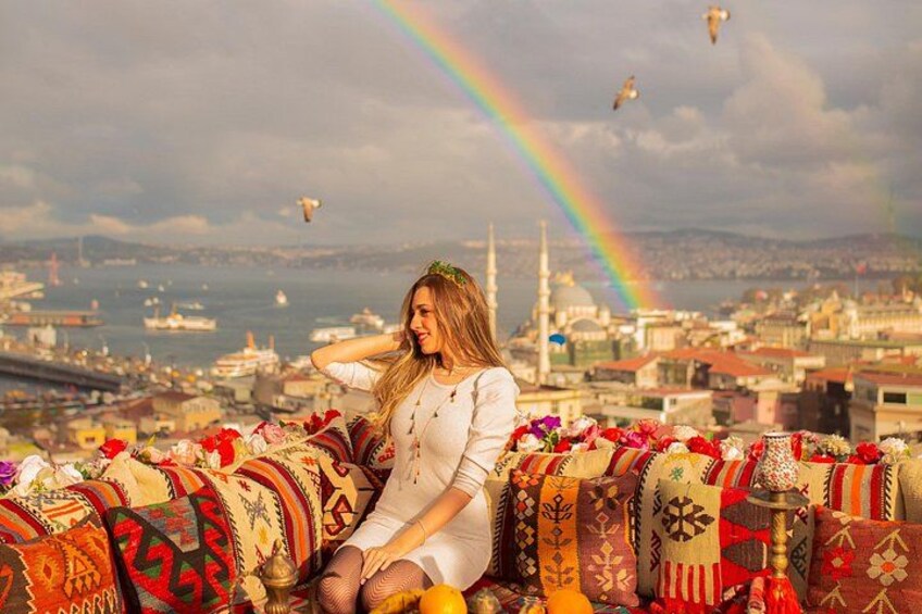 A person sitting on a colorful, patterned couch with a cityscape and a rainbow in the background. 4