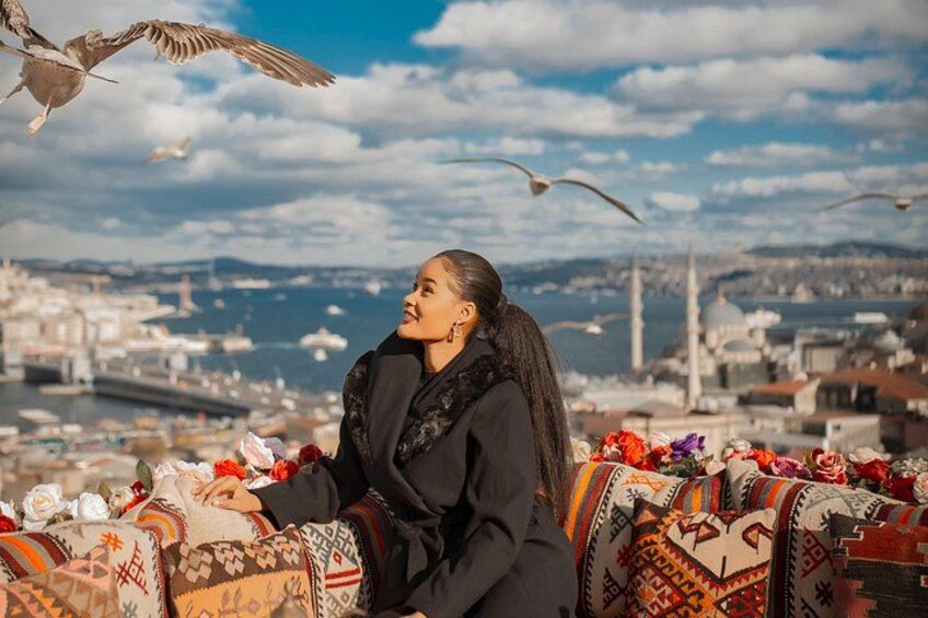 A person sitting on a patterned cushion with a cityscape in the background. 5