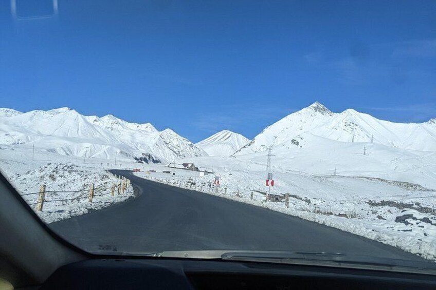 A snowy mountain road with a clear blue sky. 2