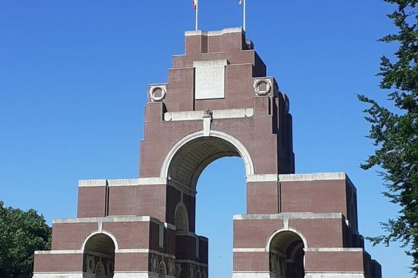 A large brick archway with inscriptions and a flag. 4