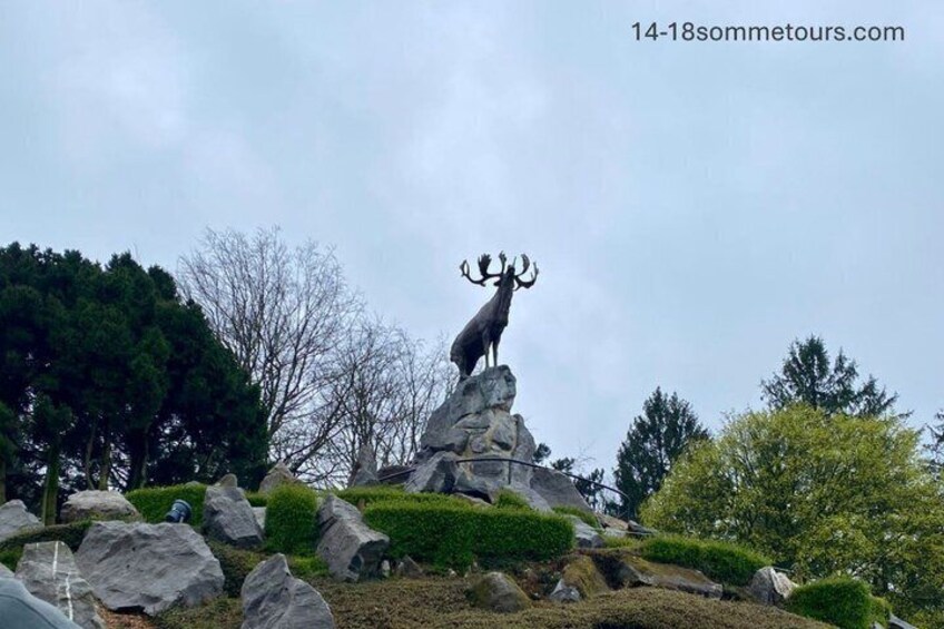 A deer statue on a rock pedestal in a landscaped garden with trees and shrubs. 3