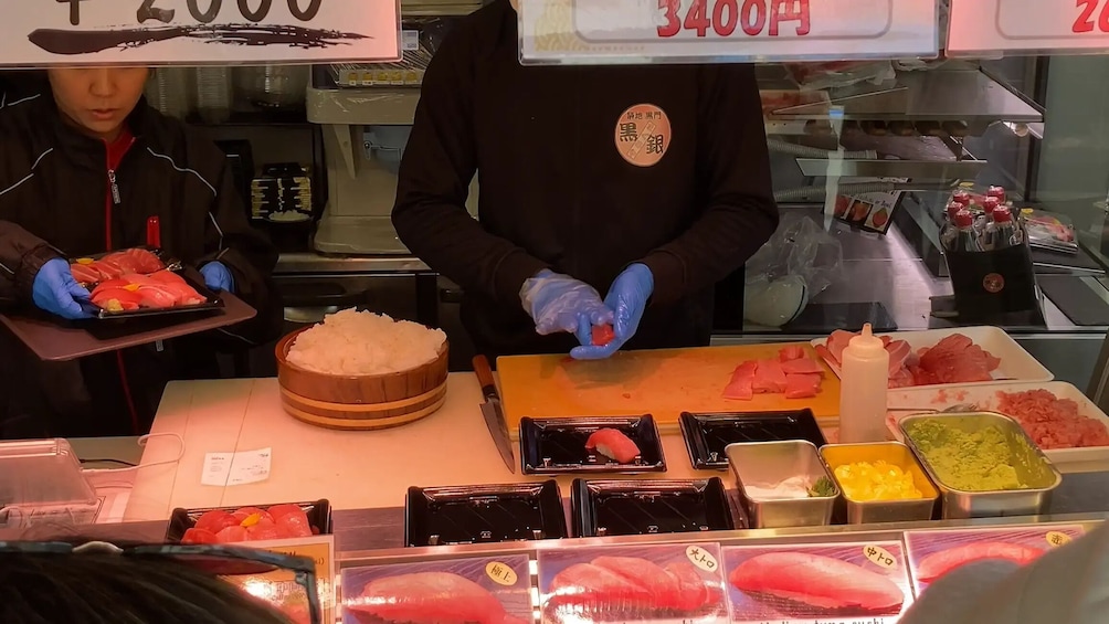 Sushi-annosten valmistusalue, jossa on erilaisia kaloja ja riisiä. 1