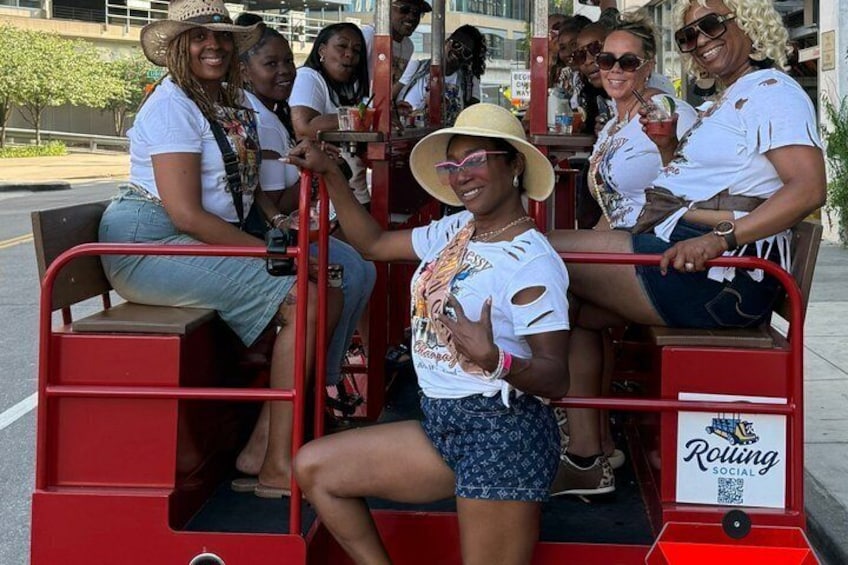 A group of people on a red trolley with a 'Rolling Social' sign. 3