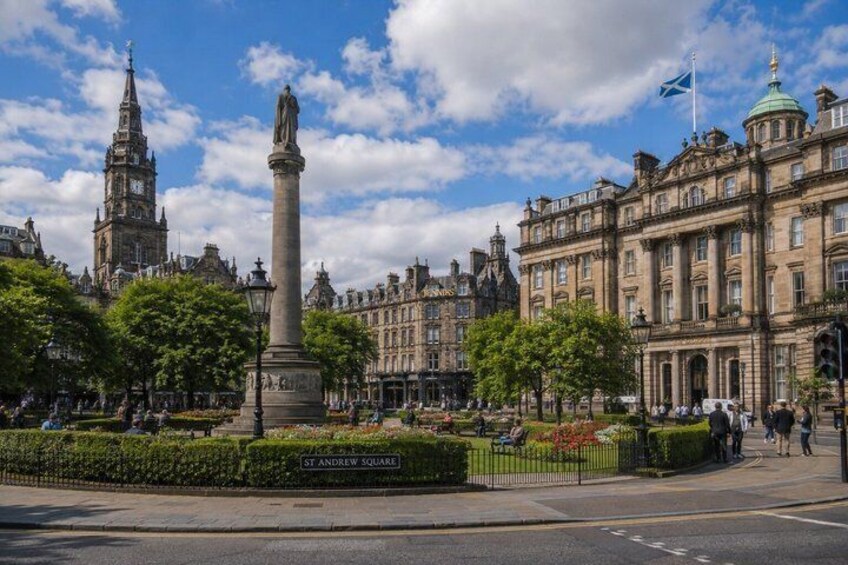 A historic square with a monument, a clock tower, and classic architecture. 5