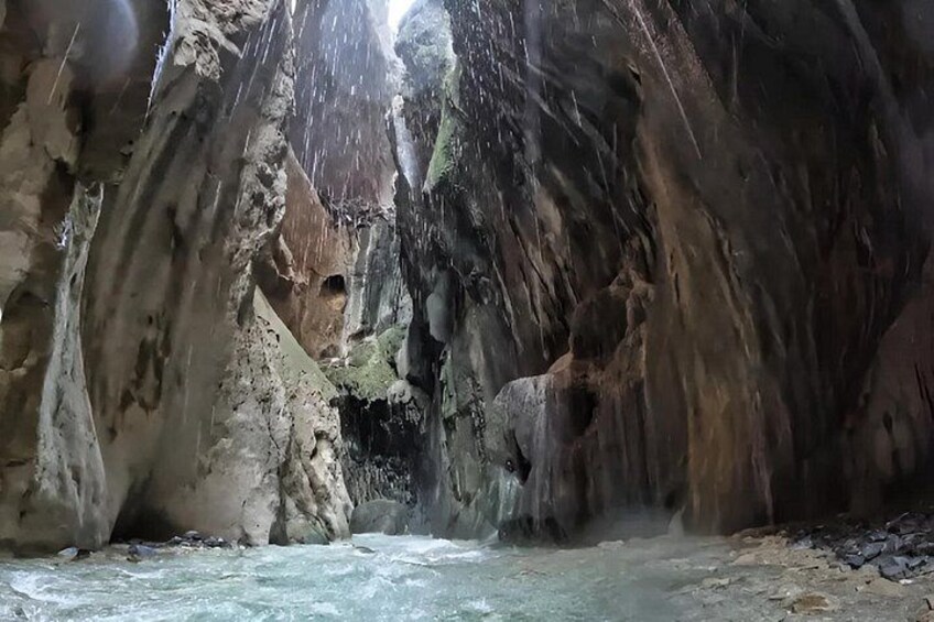 A river flowing through a rocky canyon with waterfalls and a narrow passage. 1