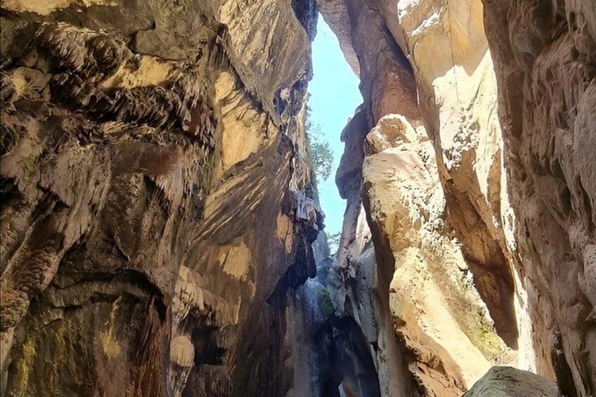 A canyon with rock formations and a narrow passageway. 5