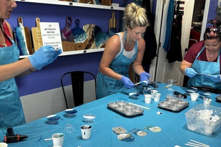 People working at a table with art supplies, including paint and brushes. 4