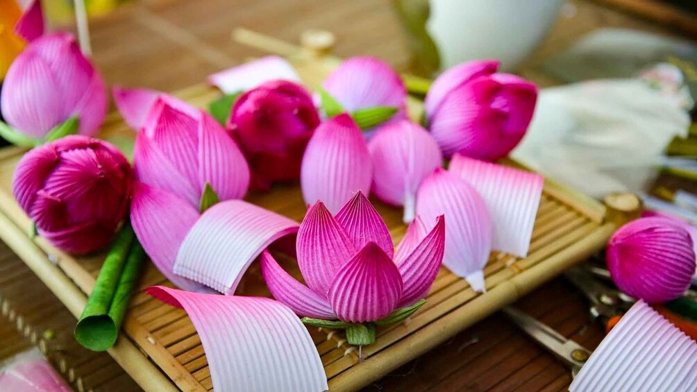 Pink lotus flowers and green leaves on a bamboo mat. 1
