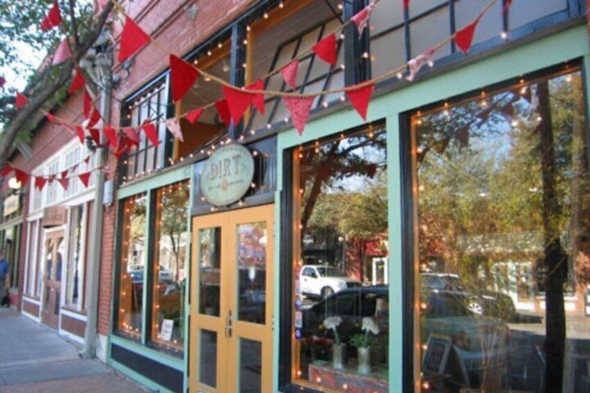 A storefront with large windows and a sign that reads 'Dirt.' 3