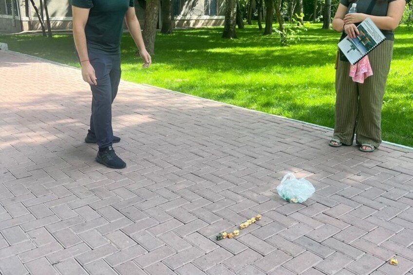 A paved walkway with a plastic bag and flowers on the ground. 5